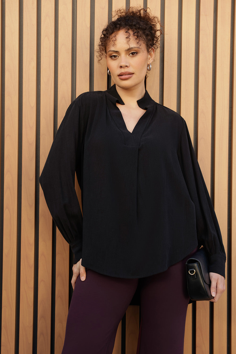 A size 10 woman wears the Ellis shirt made from Australian made graphite tencel fabric. With cuff detail and collared neckline. Made in Australia for women size 8-24.