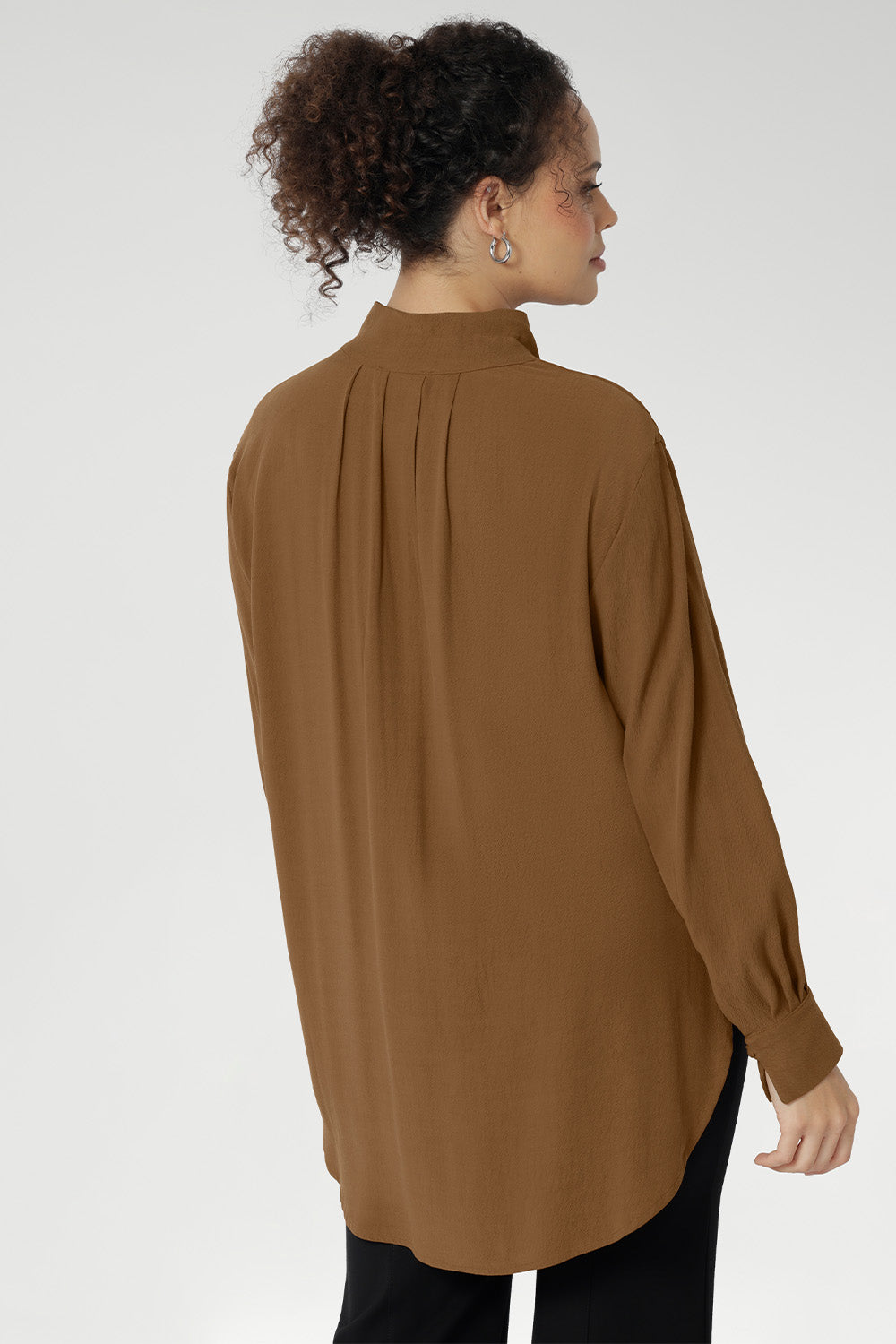Plus size woman wears lightweight, easy to wear shirt that holds its shape without stretch. In the warm neutral shade of Nuthatch, it brings subtle sophistication to everyday dressing.
Available in size 8-24.