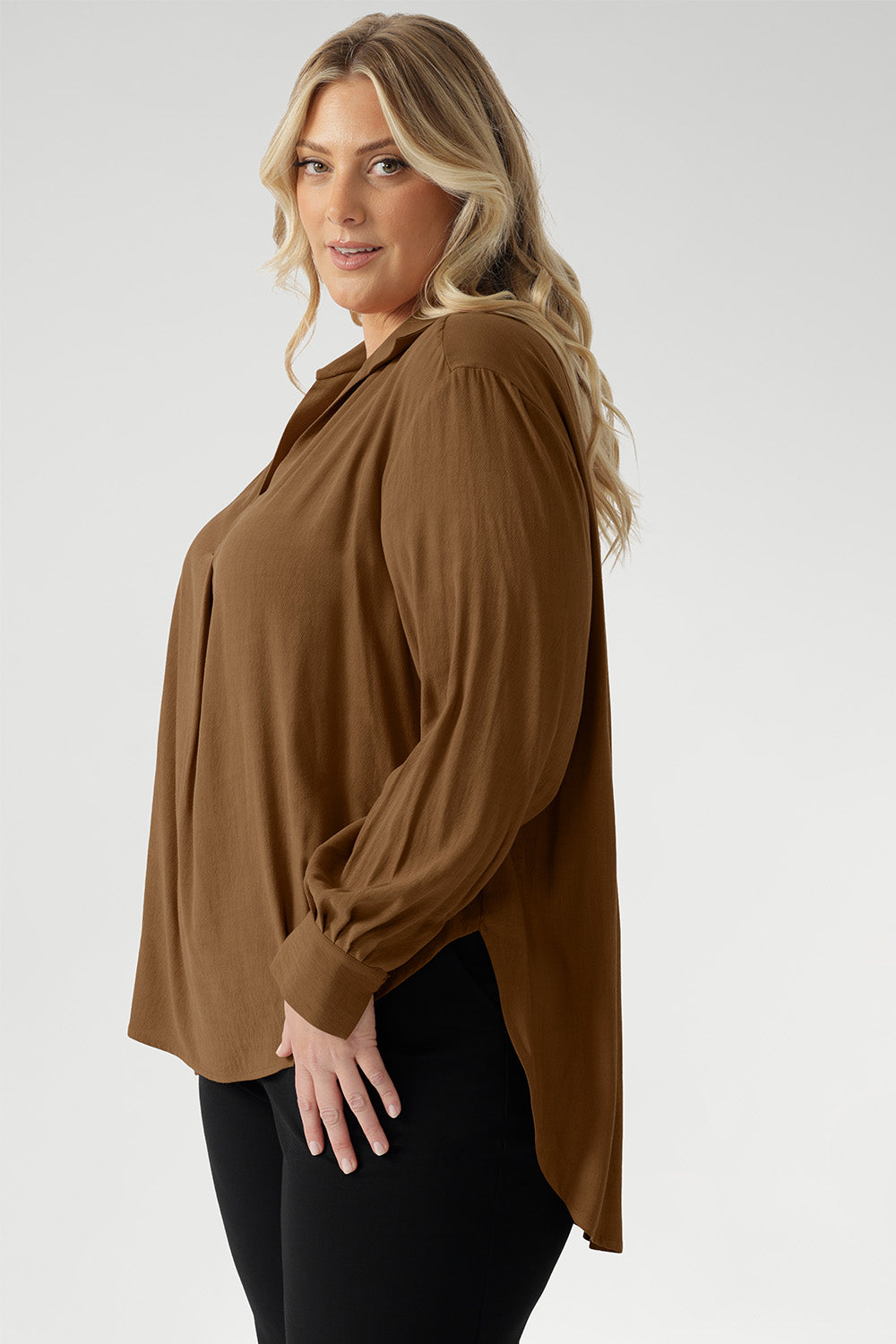 Plus size woman wears lightweight, easy to wear shirt that holds its shape without stretch. In the warm neutral shade of Nuthatch, it brings subtle sophistication to everyday dressing.
Available in size 8-24.
