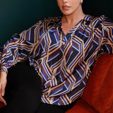 The Ellis Shirt is a contemporary swing-style top designed to bring ease and elegance to everyday dressing. Showcasing a bold geometric striped print, this eye-catching piece offers a fresh take on classic shirting with its flowing silhouette and modern detailing. Crafted for comfort and movement, the Ellis features an oversized fit that drapes beautifully and can be worn loose or styled with a front tuck for a more defined shape.