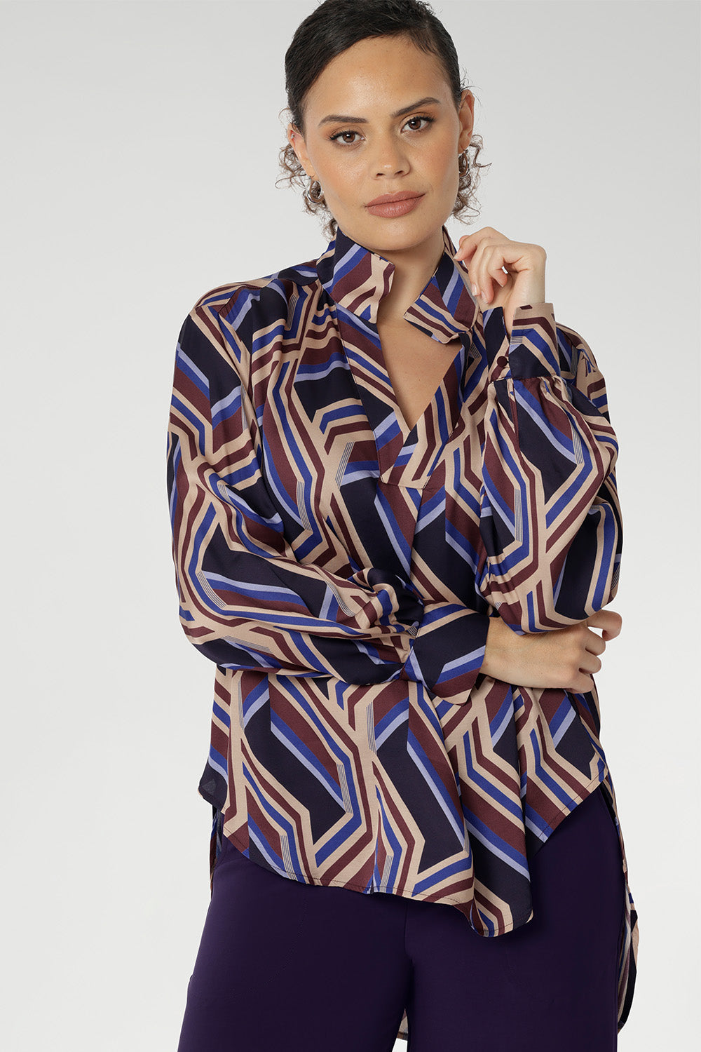 A structured collar frames the neckline, leading into a soft V-neckline with a tailored tuck at the centre, adding subtle shaping to the relaxed design. Thoughtful tuck details at the back enhance the swing silhouette, offering both style and structure.