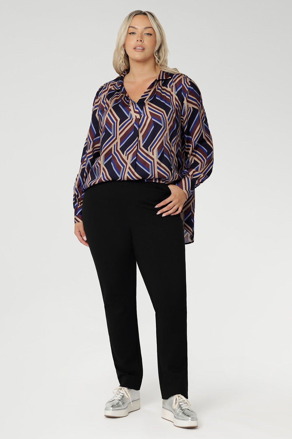A structured collar frames the neckline, leading into a soft V-neckline with a tailored tuck at the centre, adding subtle shaping to the relaxed design. Thoughtful tuck details at the back enhance the swing silhouette, offering both style and structure.