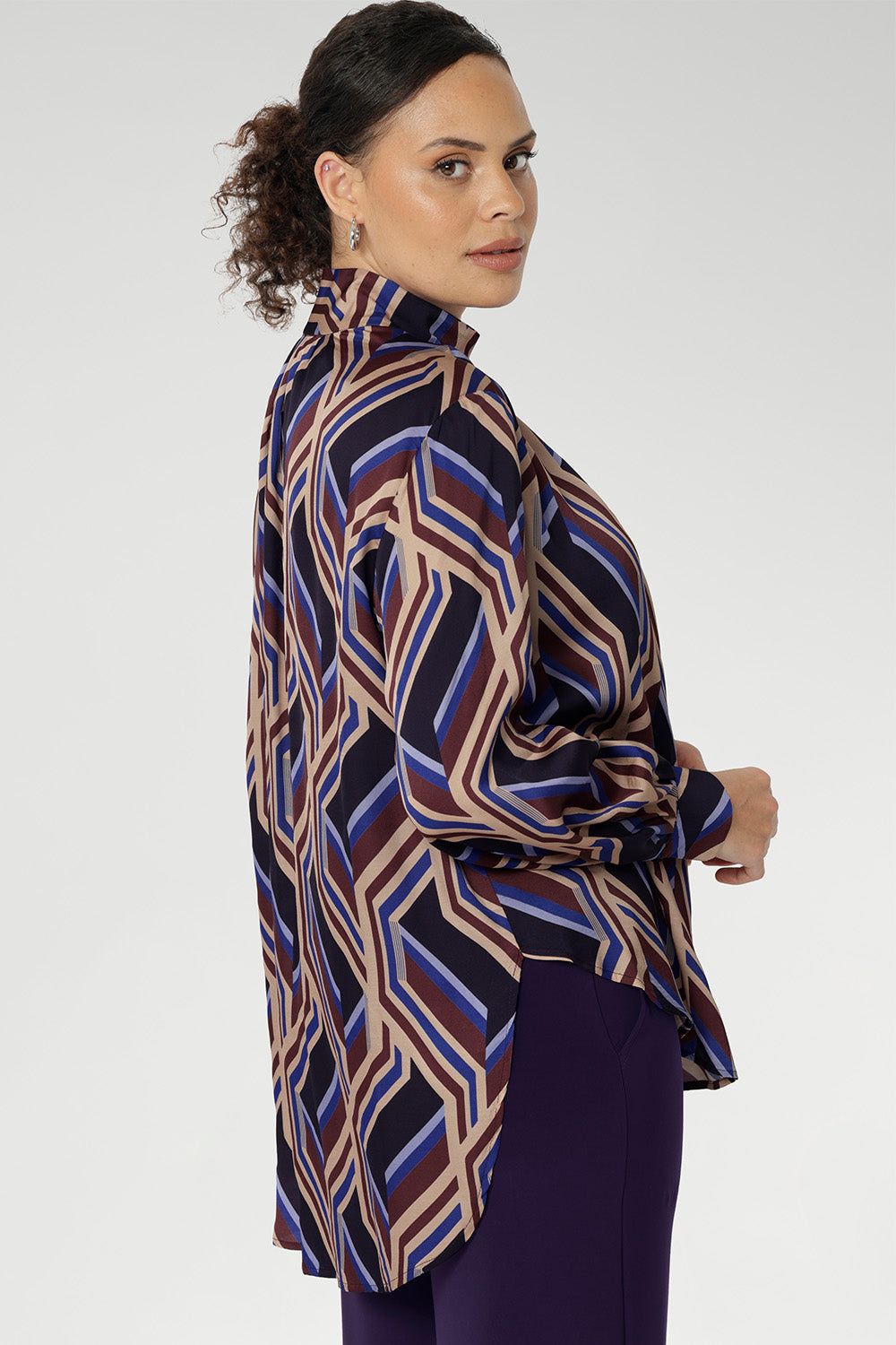 Showcasing a bold geometric striped print, this eye-catching piece offers a fresh take on classic shirting with its flowing silhouette and modern detailing. Crafted for comfort and movement.