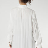 Back view of a size 10 woman wears the Ellis shirt in Vanilla tencel, a high quality made in Australia womens shirt made in breathable tencel. Inclusive size range 8-24 and made in Australia. Styled back with the Deni pants in Black velour.