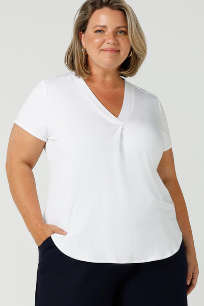 A good top for your capsule wardrobe, this V-neck tailored top in white bamboo jersey has short sleeves for summer style.  Shown on a size 18, curvy woman, this is a great plus size top for work and casual wear. Made in Australia by ethical clothing brand, Leina & Fleur, shop ladies tops in petite to plus sizes online in their online fashion boutique.
