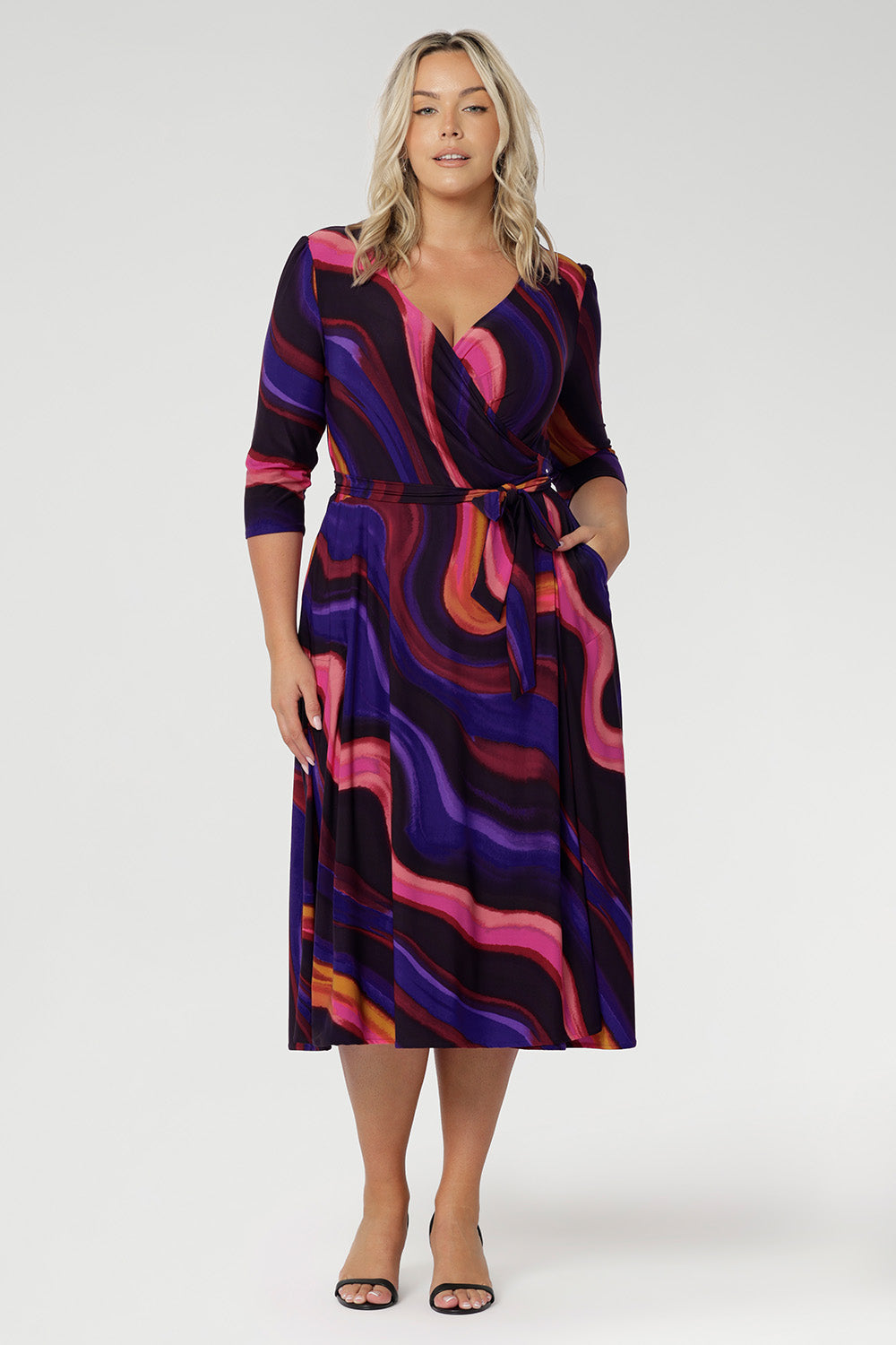 A-line skirt that falls gracefully to a midi-length hemline, offering both comfort and timeless elegance. The Fiona Dress features a functioning wrap style that allows for an adjustable fit, complemented by an elegant sweetheart neckline and extended waist ties that define the waist.