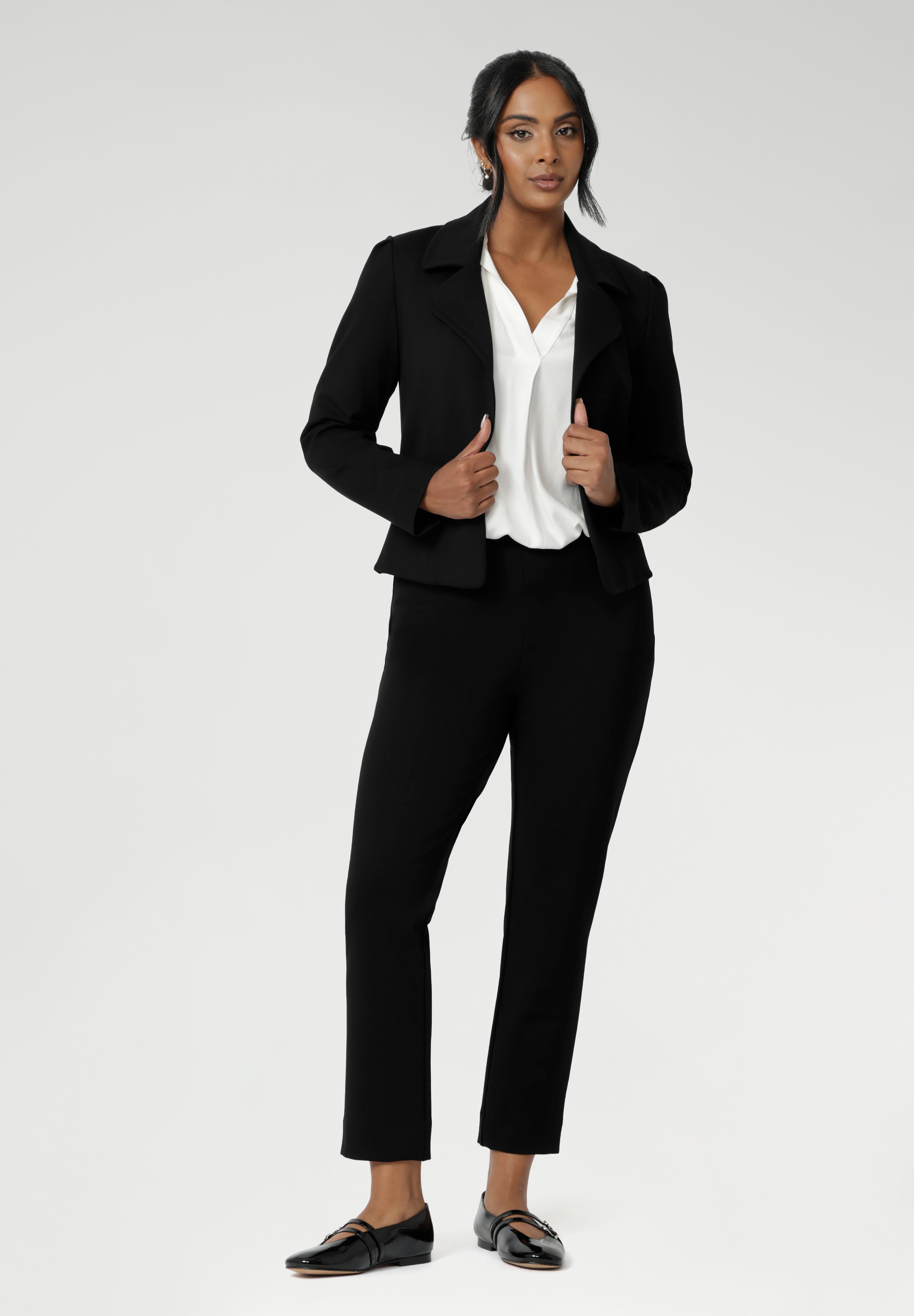 Size 10 woman wears the Garcia Jacket in Black. Tailored design with collar and comfortable stretch. Comfortable and stylish workwear for women. Size inclusive fashion and made in Australia for women size 8 - 24.