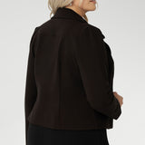 Its contemporary design features a clean front with double-layered tailored panels, complemented by refined collar and notch lapels with subtle topstitch detailing for a polished finish. A shoulder yoke and back darts enhance the fit, while full-length sleeves with gentle tucks at the sleeve heads add a touch of softness to the overall look.