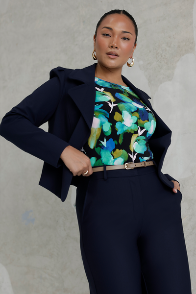 A size 10 woman wears the Mason top in Canopy, a green watercolour print top with a green watercolour splatter print. Styled back with navy Garcia and Navy Kade pants. Made in Australia for women size 8 - 24. 