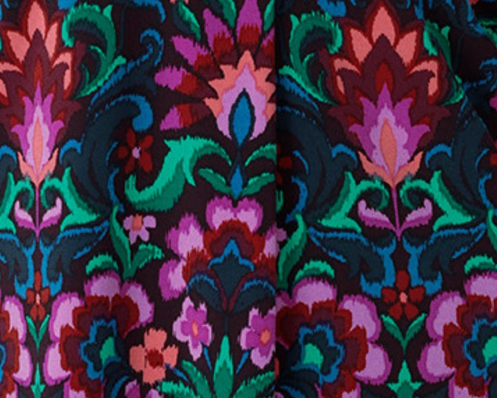 This vibrant printed fabric, featuring bold hues of pink, green, burgundy, and blue, is used to create a stunning collection of women’s spring fashion, including a maxi wrap dress, culotte pants, and a flutter sleeve top. Proudly made in Australia and available in sizes 8 to 24.