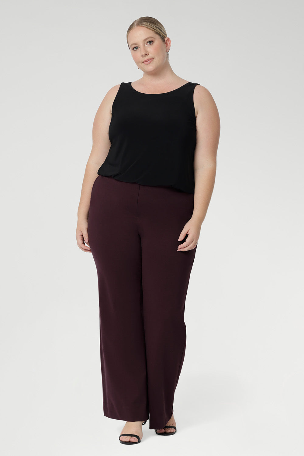The Harlee Reversible Top—a must-have essential that effortlessly blends comfort, style, and practicality. Crafted from our signature dry-touch stretch jersey. Plus size model wears her reversible cami with boot leg style pants in the wine colour.