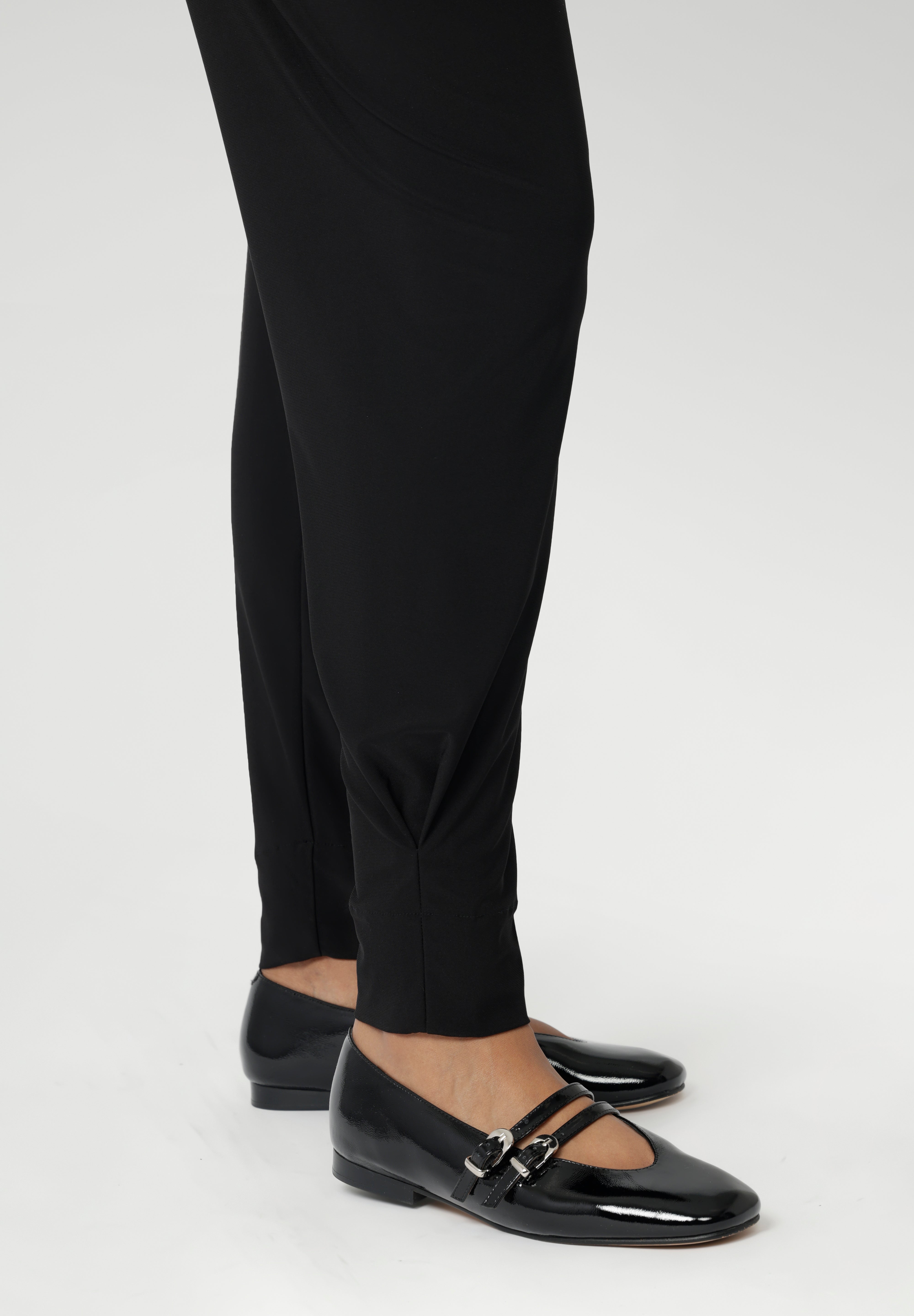 These stylish 7/8 length pants feature single inside seam legs, a tapered leg fit, and ankle cuffs with a tuck detail for a sleek, modern look.