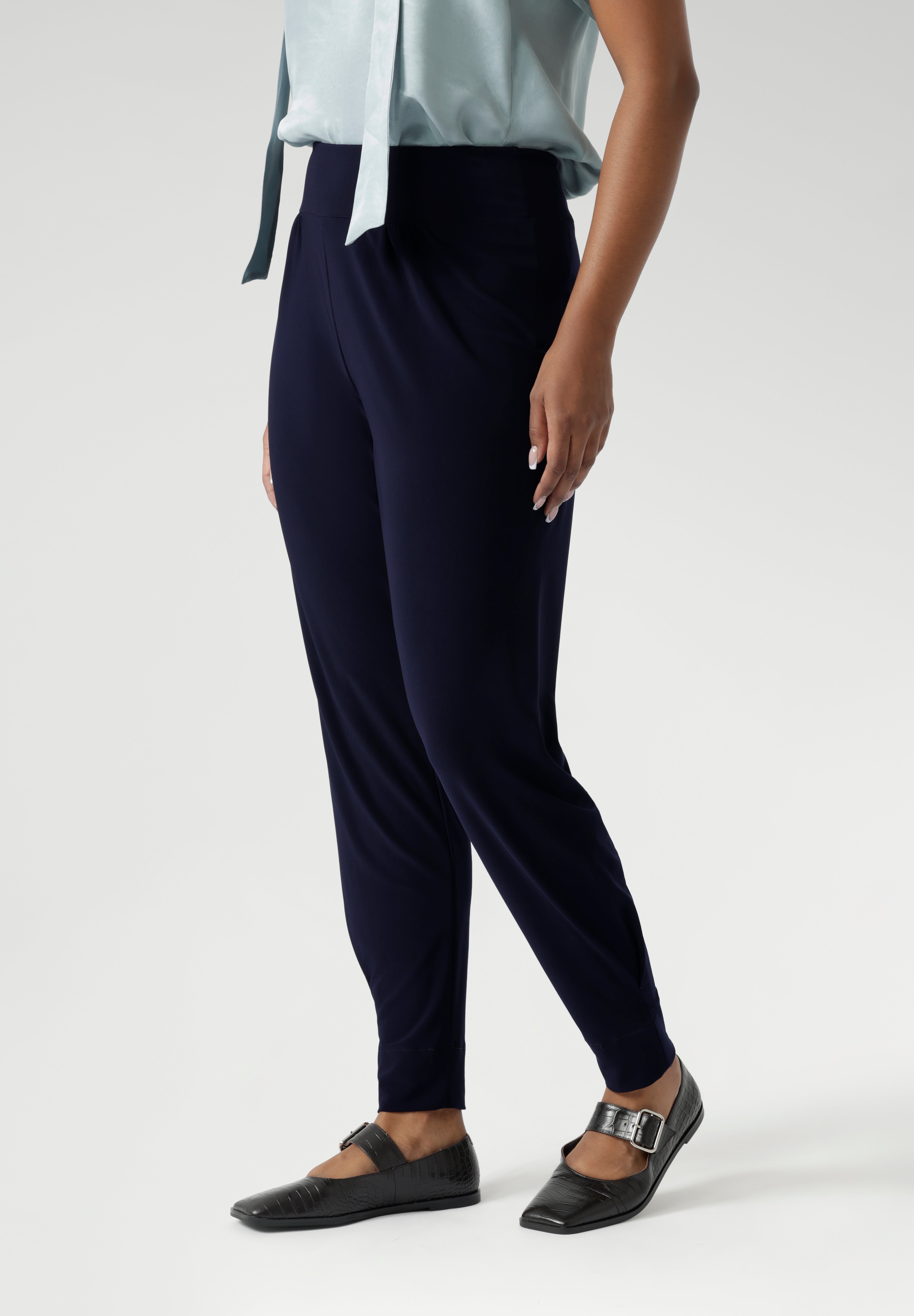 These stylish 7/8 length pants feature single inside seam legs, a tapered leg fit, and ankle cuffs with a tuck detail for a sleek, modern look.