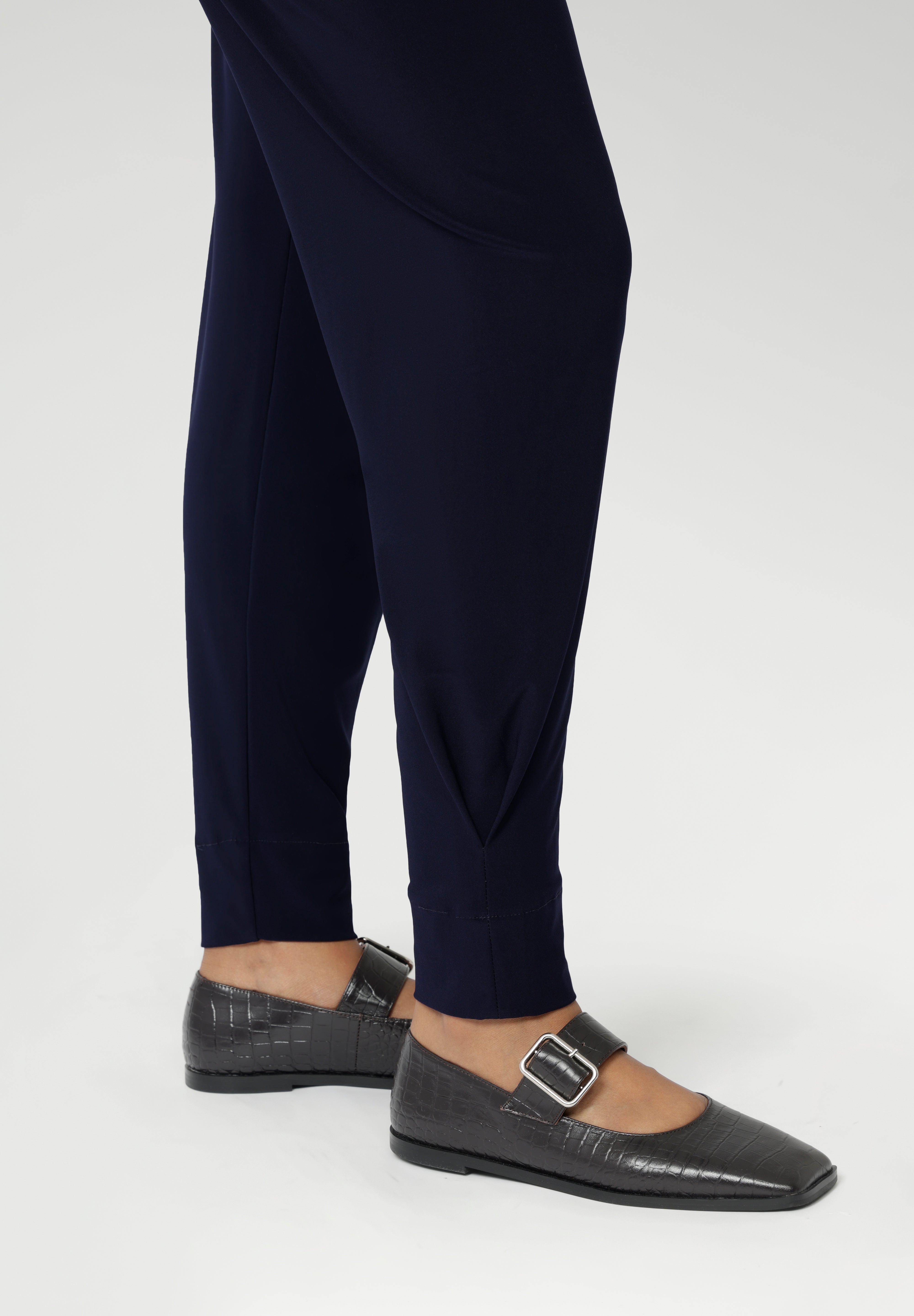 These stylish 7/8 length pants feature single inside seam legs, a tapered leg fit, and ankle cuffs with a tuck detail for a sleek, modern look.
