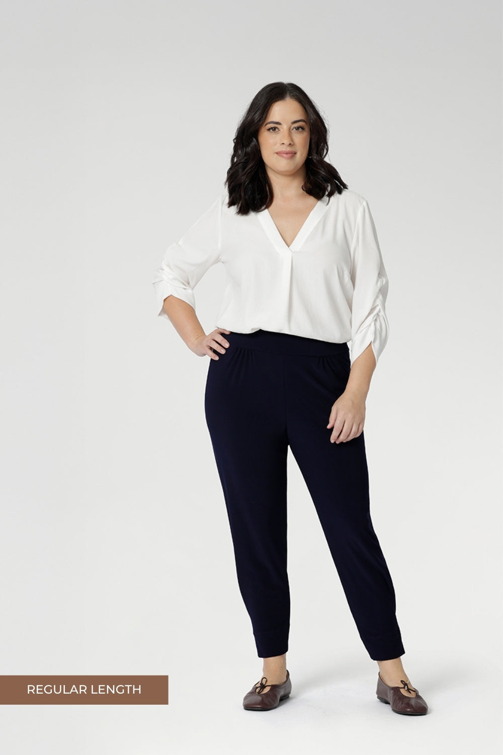 Petite height model wears travel pant that feature dropped crotch & tapered legs. Model is size 10. Travel ready pants made from stretchy jersey for ultimate comfort. Made for Australian and New Zealand women, by clothing brand Leina & Fleur. Now available in sizes 8-24 and in 2 lengths.