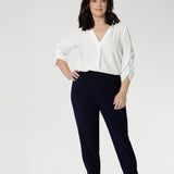 Petite height model wears travel pant that feature dropped crotch & tapered legs. Model is size 10. Travel ready pants made from stretchy jersey for ultimate comfort. Made for Australian and New Zealand women, by clothing brand Leina & Fleur. Now available in sizes 8-24 and in 2 lengths.