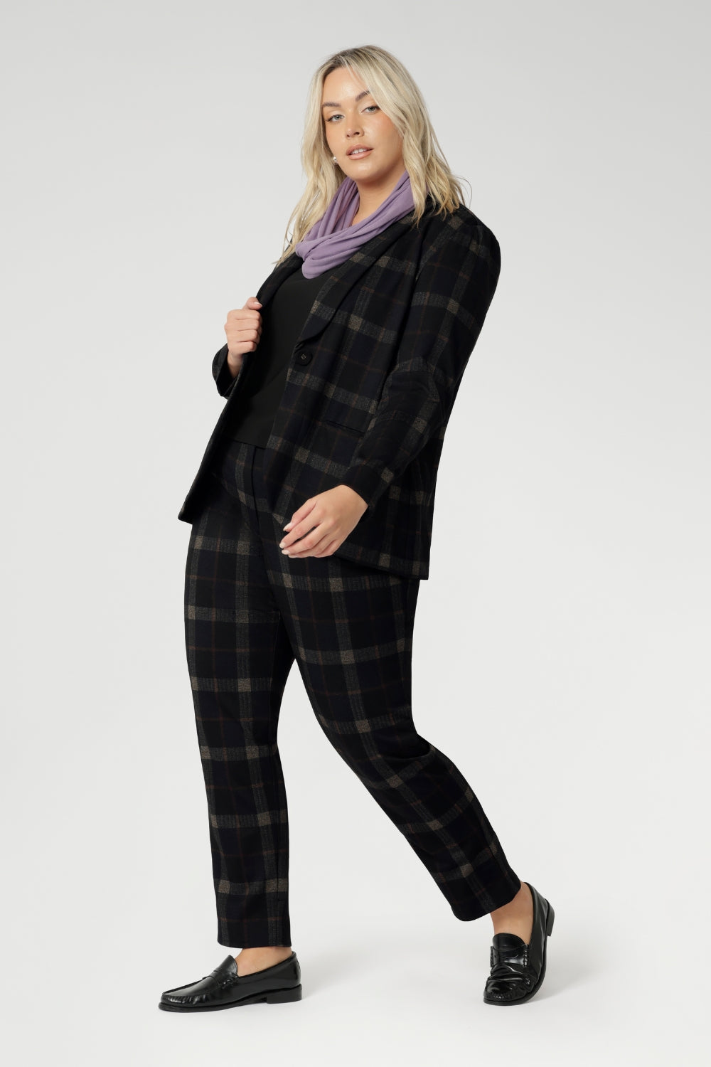 Infinity Knit Scarf adds timeless elegance to any outfit. For a coordinated, polished look, style it with the matching Zara Top in the same fabric. Easy care easy wear combination for warmth, comfort, and elevated day-to-day dressing. Size 18 woman wears her Lilac Winter Scarf with Plaid Suit.