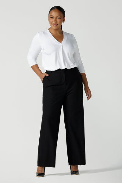 A size 16 curvy women wears the Kade pant in Black. A high waist pant in technical stretch ponte. High waisted design with belt loops, pockets and fly front detail. Made in Australia for women size 8 - 24.