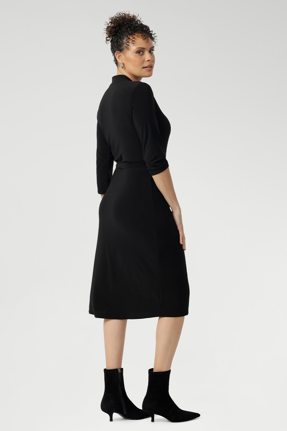 This elegant wrap dress in black jersey fabric is a timeless addition to your workwear collection, blending minimalist design with premium comfort and tailored sophistication.