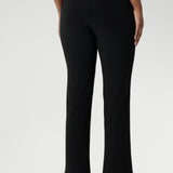 Size 10 model pairs black pants with white top & black loafers for a casual look.