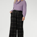 Designed to move with you, this collection offers refined silhouettes that transition effortlessly from work to smart-casual settings. Plus size woman wears her Kade wide leg pants with Lilac coloured top and scarf & black kitten heels.