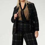 Designed for women who want style that works across occasions, this jersey top blends comfort with quiet sophistication. The soft V-neckline is accented by attached neck ties in a warm coffee tone, offering styling versatility. Plus zie woman wears her neck tie top under plaid suit set with matching blazer and wide leg pants.