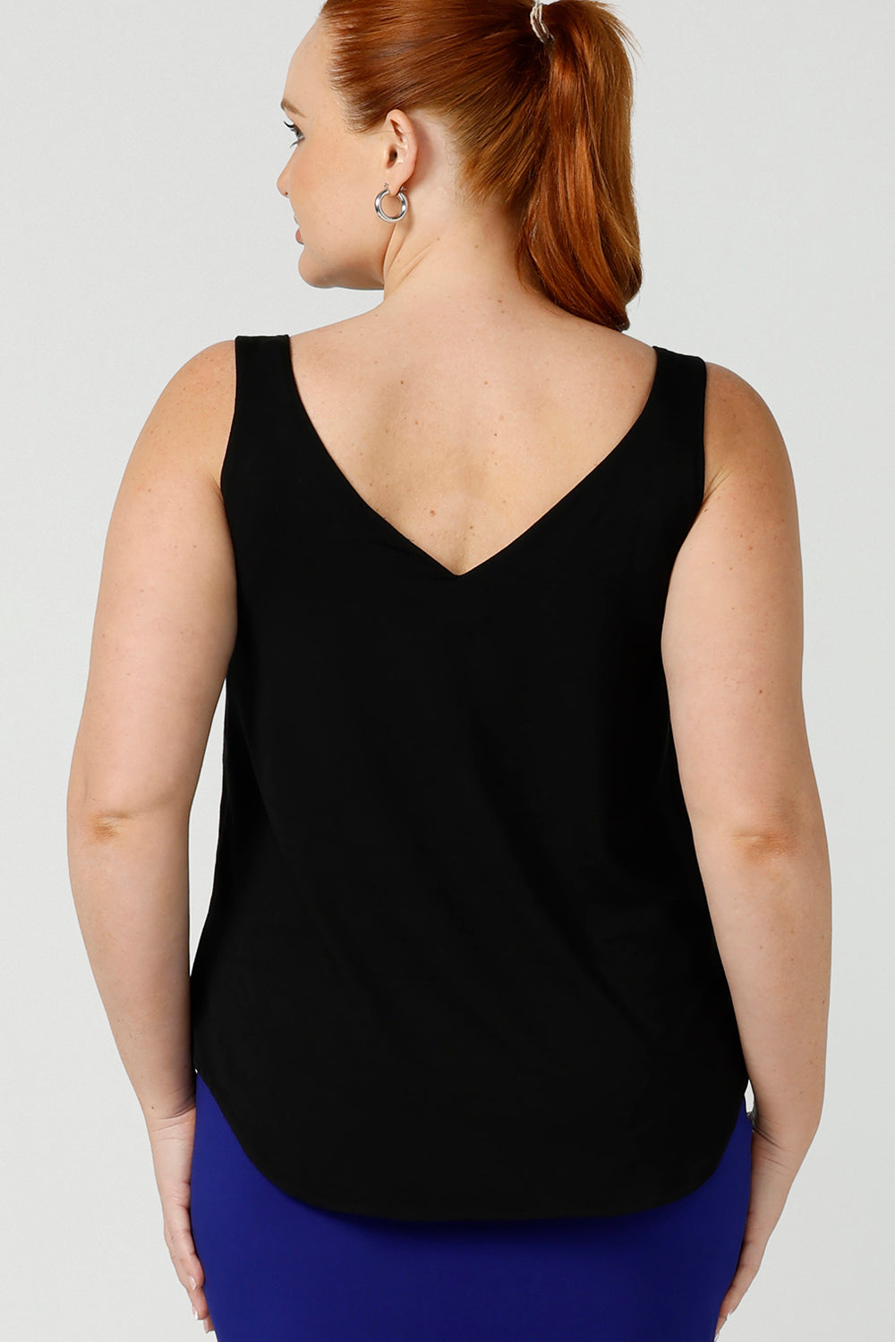 Back view of a size 12, curvy woman wears a bamboo cami. In black bamboo jersey, this top is a good addition to your capsule wardrobe for weekend wear, work and travel. Shop Australian-made dresses online is sizes 8 to 24.