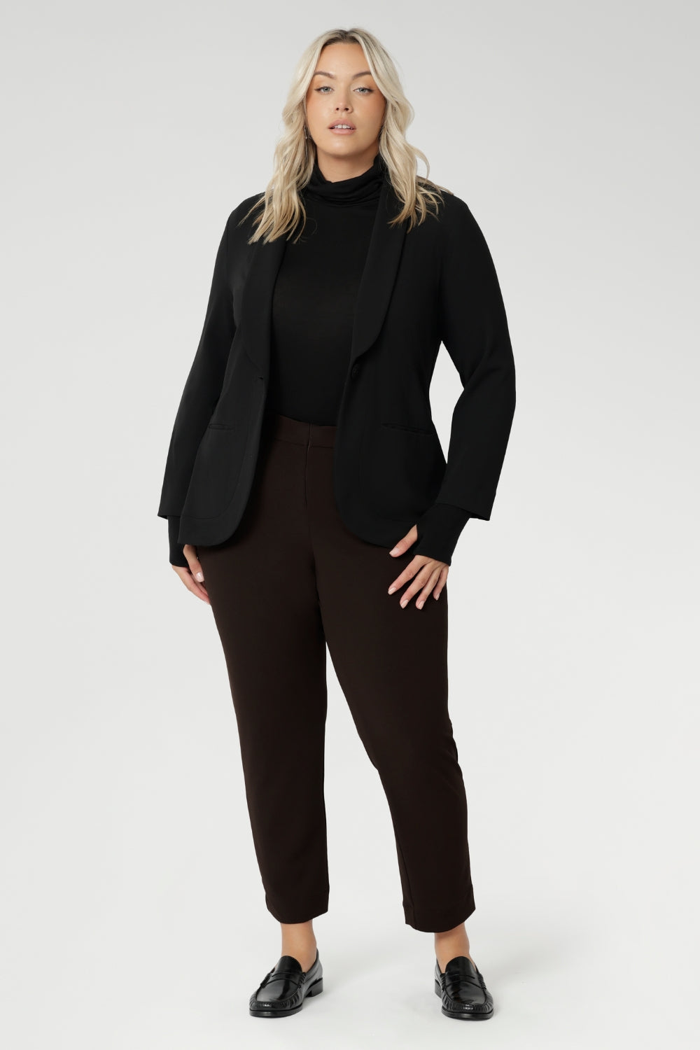 Perfect for layering or wearing on its own, the Kean Top is ideal for everything from casual outings to travel and workwear. Available in inclusive sizes 8 to 24, this versatile piece is as practical as it is polished—making it a must-have for your transitional wardrobe. Size 18 model wears Kean Top black with brown pants and a black blazer.