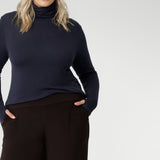 Size 18 woman wears long-sleeved top that features convenient thumb holes for added comfort and warmth and a high turtle neck. Crafted from lightweight, warm tencel wool fabric and in sizes 8-24.