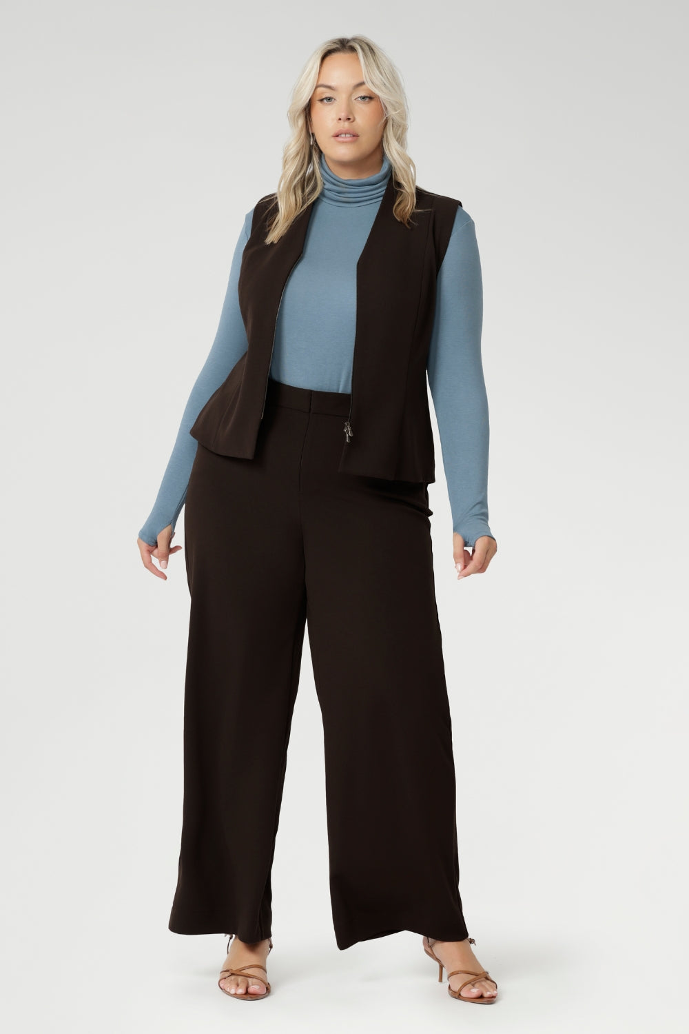 Made from a blend of stretchy Tencel wool fabric, it offers both flexibility and coziness, making it the perfect layering piece for cooler weather. Size 18 model wears her turtle neck top under her soft suiting, pairing her Pennyworth vest over the tencel wool top.
