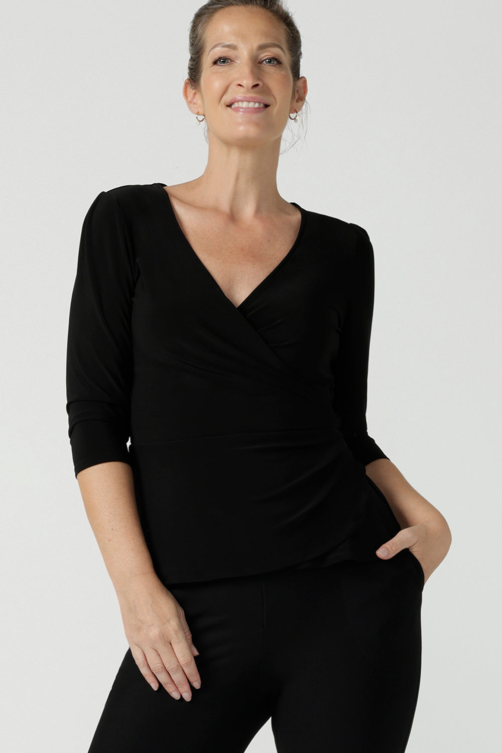 Size 10 woman wears the Kyle top in Black soft jersey. A soft wrap top made in Australia for women size 8 - 24. The perfect work to weekend top in comfortable and easy care jersey. Made in Australia for women size 8 - 24. 