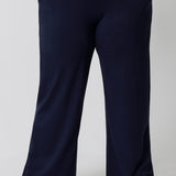 Close up of good lounge pants for curvy women. A size 18 wears straight, wide leg navy blue, plus size lounge pants in bamboo jersey with a blue and white print modal cami top. Breathable and thermo-regulating this is a good pyjama set for night sweats and hot flushes. Stay cool this summer nights with breathable sleepwear by L&F Australia.