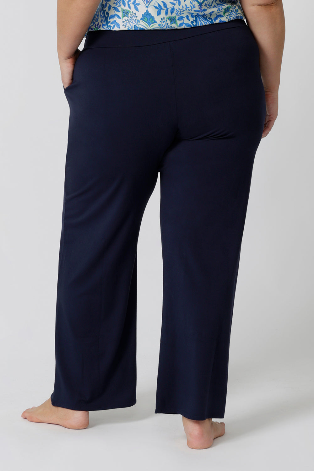 Back view of lounge pants for curvy women. A size 18 wears straight, wide leg navy blue, plus size lounge pants in bamboo jersey with a blue and white print modal cami top. Breathable and thermo-regulating this is a good pyjama set for night sweats and hot flushes. Stay cool for summer nights with breathable sleepwear by L&F Australia in sizes 8-24.