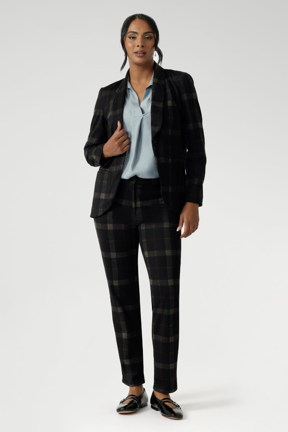 Lulu brings a sleek, modern edge to both workwear and smart-casual styling. This versatile pant is part of the Cocoa Plaid collection, a striking suiting range in a deep navy and graphite check. Size 10 woman wears her tailored pant with ice blue coloured blouse and matching plaid blazer.