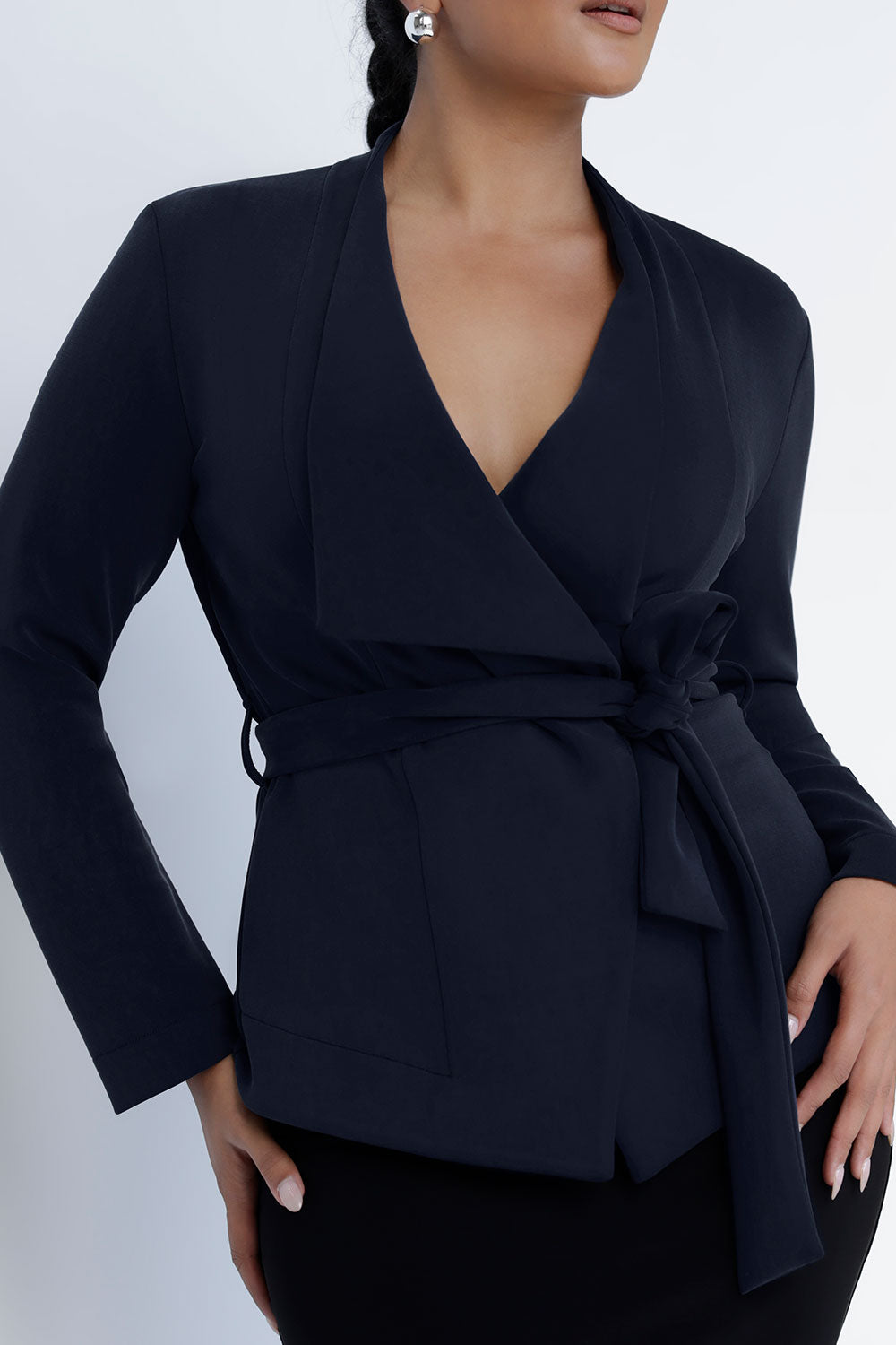 A size 10 woman wears the Lyndon Jacket in Bluestone. A wrap style jacket with waist belt and collared neckline. Made in soft luxurios modal. Rug up on the way to the office or weekend winter get away. Made in Australia for women size 8 -24.