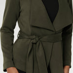 Designed in a flattering wrap style, it features double-layered, angled front panels for a modern edge and a detachable waist tie with belt loops, allowing you to wear it open or cinched to define your silhouette.