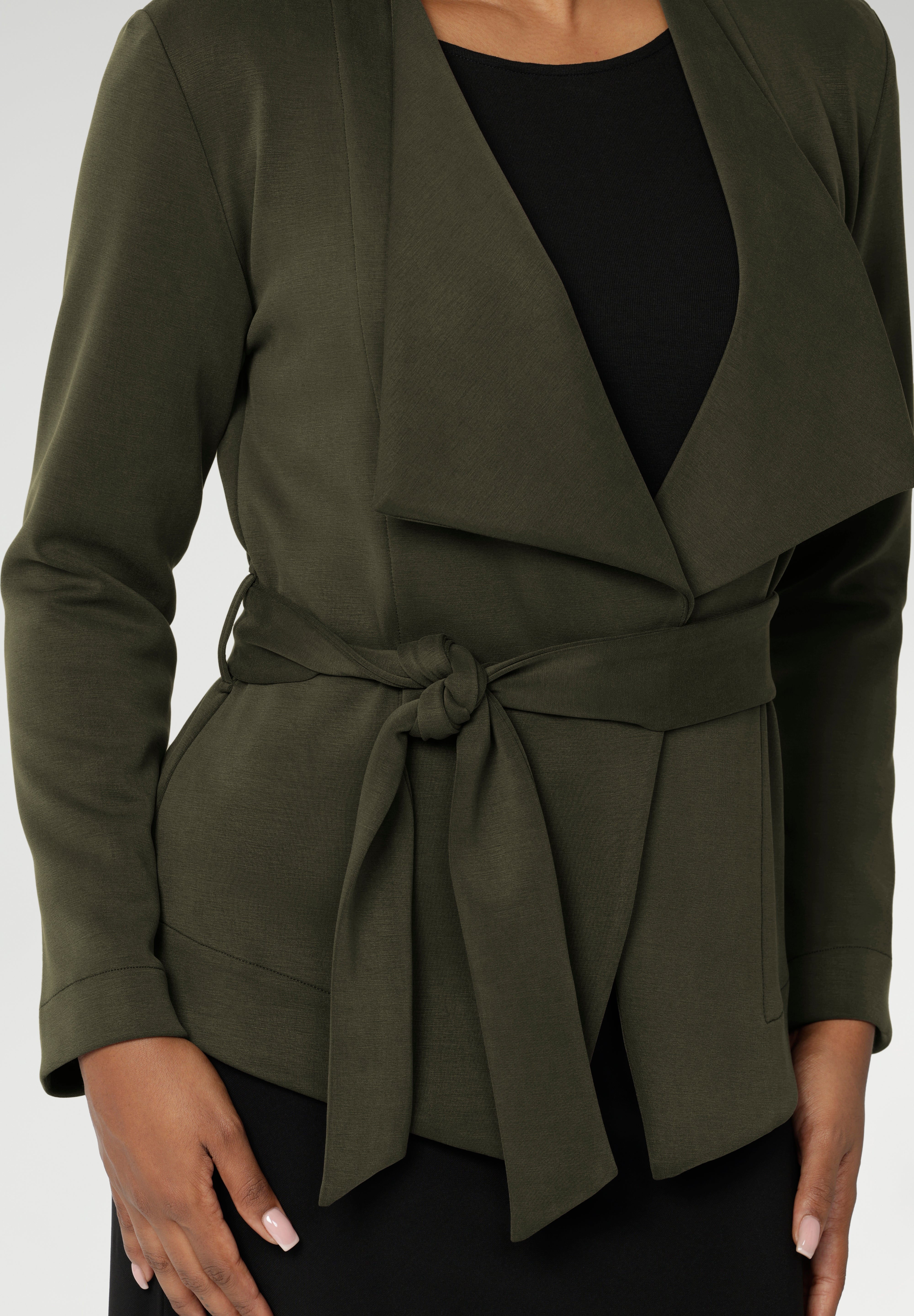 Designed in a flattering wrap style, it features double-layered, angled front panels for a modern edge and a detachable waist tie with belt loops, allowing you to wear it open or cinched to define your silhouette.