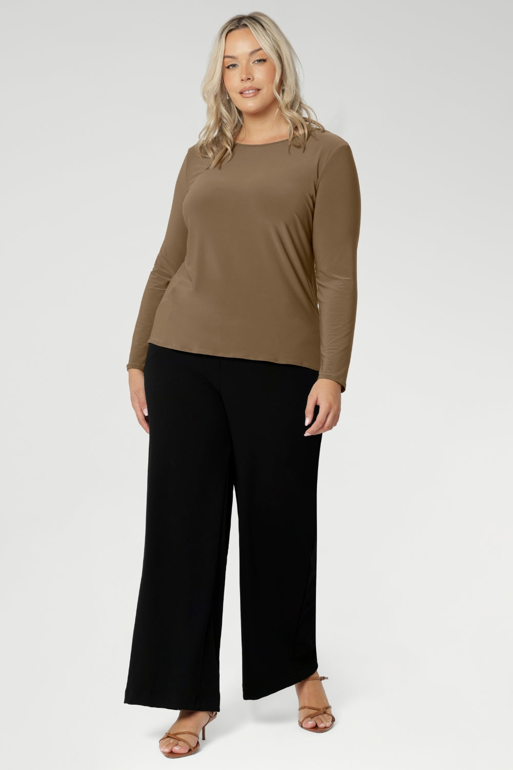 The Mason Top is a must-have addition to any woman’s wardrobe, offering timeless style and versatility for both workwear and casual looks. Proudly Australian made, this long-sleeved top is seen worn with black wide leg pants on a size 18 woman.