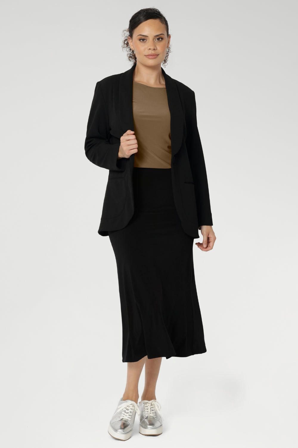 Designed with a classic boat neckline, the Mason Top features a close-to-body silhouette with flattering bust darts for subtle shaping, making it ideal for layering or wearing on its own as the seasons change. Size 10 woman wears her Mason Top in Coffee with Merit Blazer in Black.