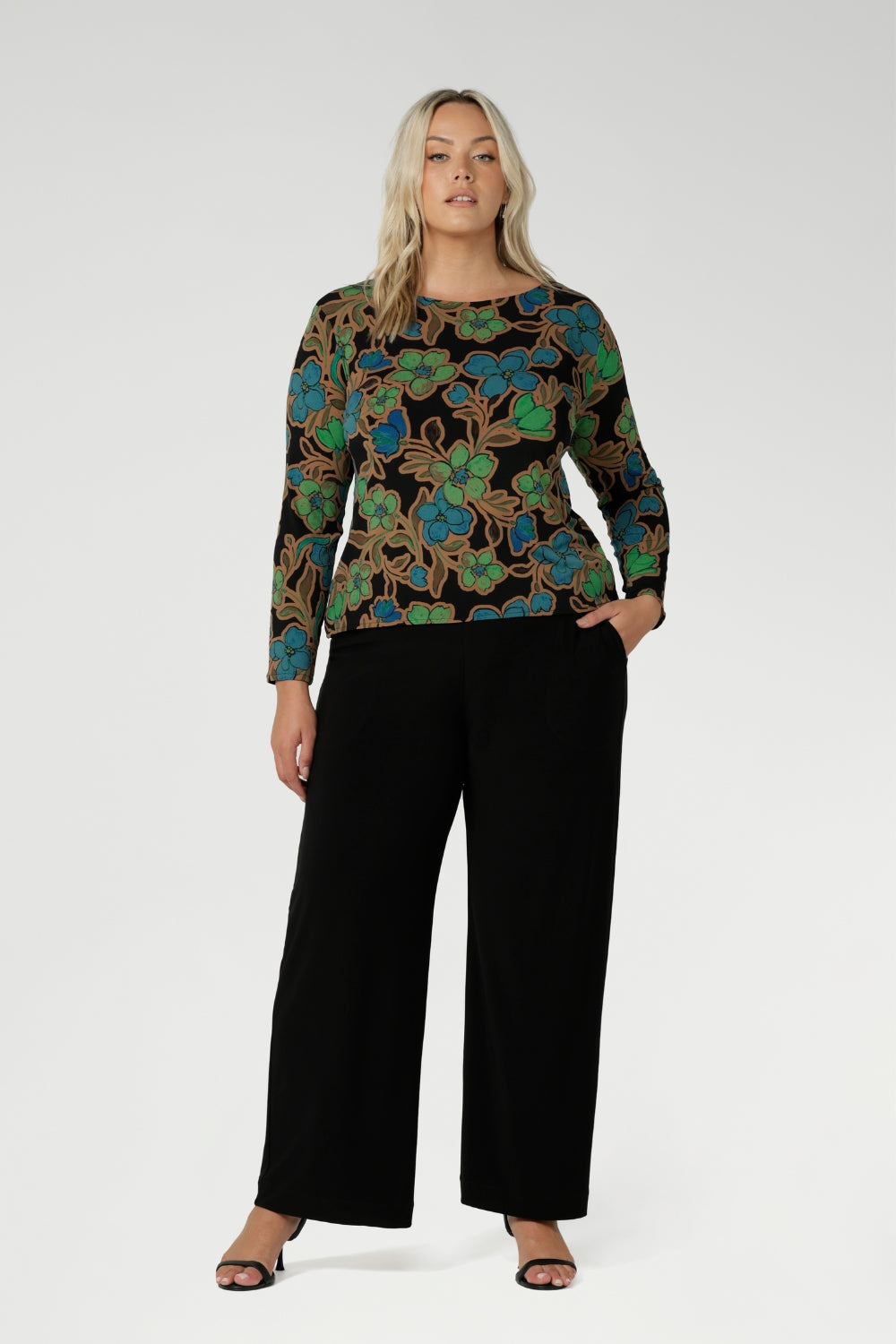 Plus size woman wears her printed top with classic womans workwear pants. Available in sizes 8-24, this top is Australian Made, ensuring quality and craftsmanship. It’s a versatile piece that will effortlessly elevate your everyday wardrobe.