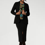 Size 10 woman wears her floral top paired with midi length skirt and black easy care blazer. The long sleeves provide added warmth, while the straight hemline at the front and curved hemline at the back, which sits longer, give it a modern touch.