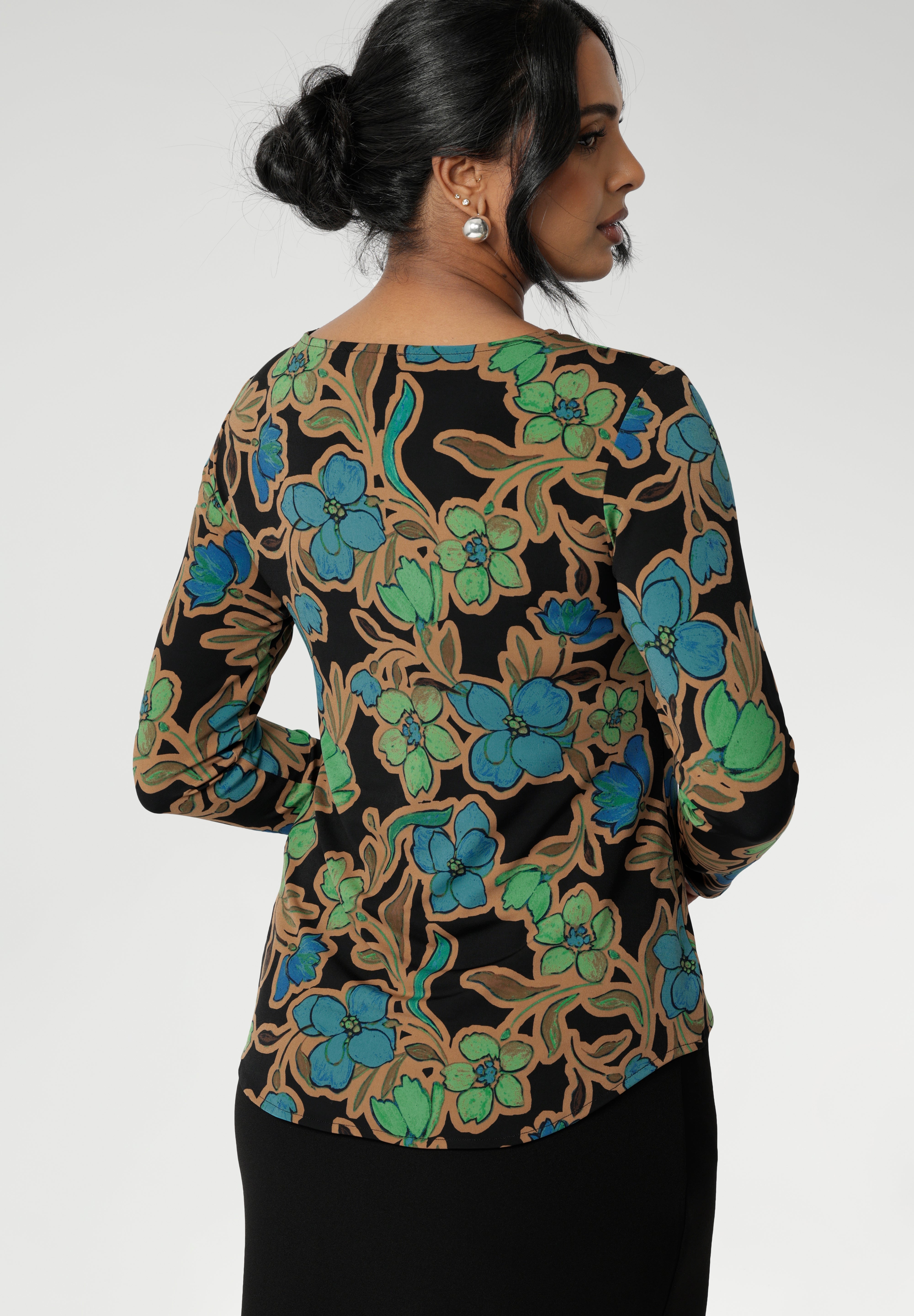 The Mason Top is an essential addition to your wardrobe, perfect as a base layer when the weather cools. Featuring chic, clean lines and an elegant boat neckline, this top offers effortless style in the Secret Garden print. The design features a black base adorned with a floral pattern in soft shades of opal blue, green, and burnt gold.
