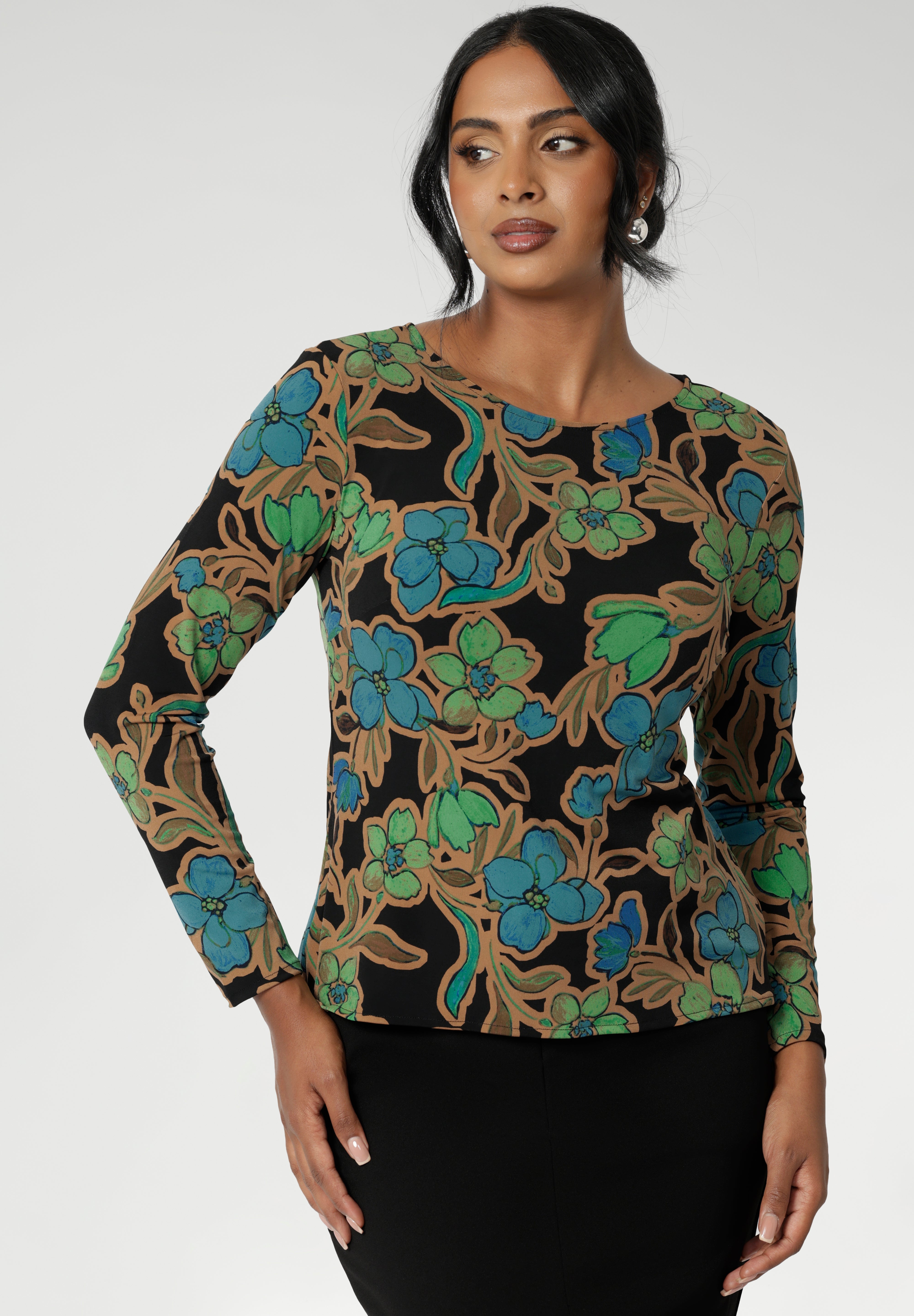 Size 10 woman wears a boat neck jersey top with long sleeves. In a floral print, this slim-fit jersey top sits well under jackets for workwear.