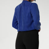 The Matisse Shirt in Cobalt is a pull-on style with a tie neckline, crafted from soft, fluid fabric. Blouson sleeves and buttoned cuffs add a polished finish. Matisse is a semi-fitted pull on style V-neckline shirt with extended neck ties, back pleats and bishop sleeves. Crafted from suede touch Tencel that has a luxurious feel and drape. Proudly made in Australia in sizes 8-24.