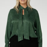 Crafted from suede touch Tencel that has a luxurious feel and drape. Proudly made in Australia in sizes 8-24. The Matisse Shirt in Deep Green is a pull-on style with a tie neckline, crafted from soft, fluid fabric. Blouson sleeves and buttoned cuffs add a polished finish. Matisse is a semi-fitted pull on style V-neckline shirt with extended neck ties, back pleats and bishop sleeves.