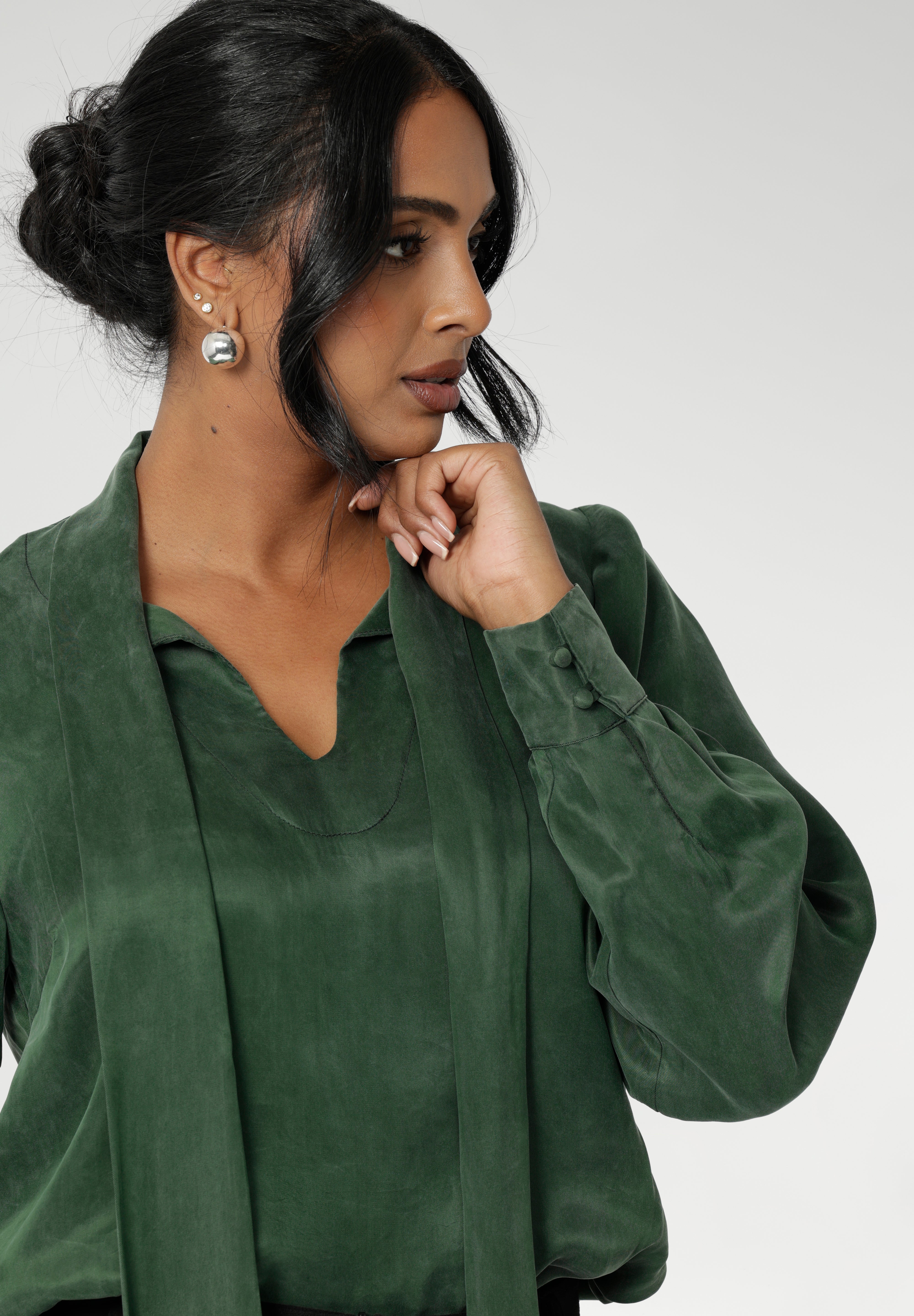 Crafted from suede touch Tencel that has a luxurious feel and drape. Proudly made in Australia in sizes 8-24. The Matisse Shirt in Deep Green is a pull-on style with a tie neckline, crafted from soft, fluid fabric. Blouson sleeves and buttoned cuffs add a polished finish. Matisse is a semi-fitted pull on style V-neckline shirt with extended neck ties, back pleats and bishop sleeves.