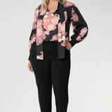 While the fabric offers no stretch, its fluid drape ensures a flattering, comfortable fit. Ideal for pairing with tailored separates or dressed down with denim, the Matisse Shirt brings timeless romance to your wardrobe. Plus size woman wears floral blouse tucked into her straight leg pants.