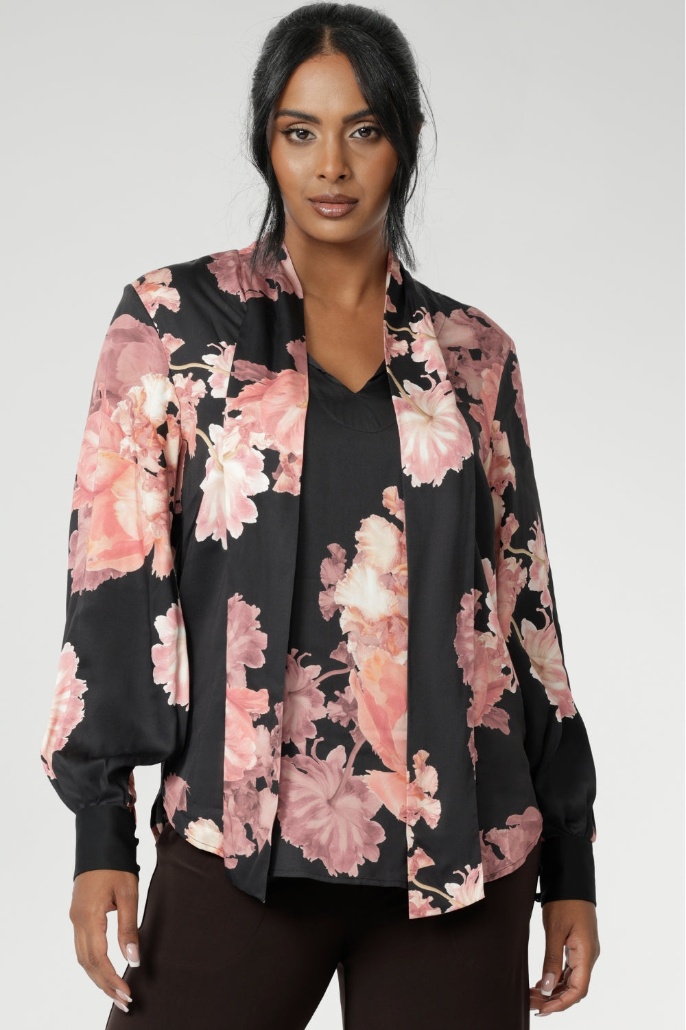 The romantic floral print blooms across a black satin base, with delicate pink tones adding depth and softness to the look. Elegant bishop sleeves with functioning covered button cuffs create a polished silhouette, while gentle pleats at the back neckline provide ease and subtle movement. Finished with a classic shirttail hemline, the Matisse Shirt can be styled tucked or untucked for effortless sophistication.