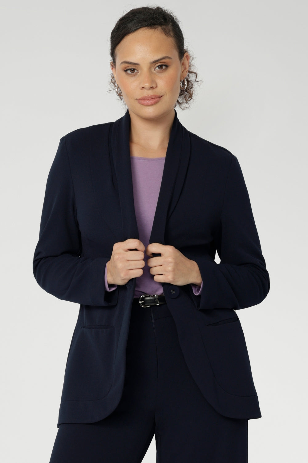 Size 10 women wearing a Navy Merit blazer with Scuba crepe and collar. It has functional patch pockets and tailored shawl collar. Stylish corporate casual wear for women. Made in Australia size 8 - 24.