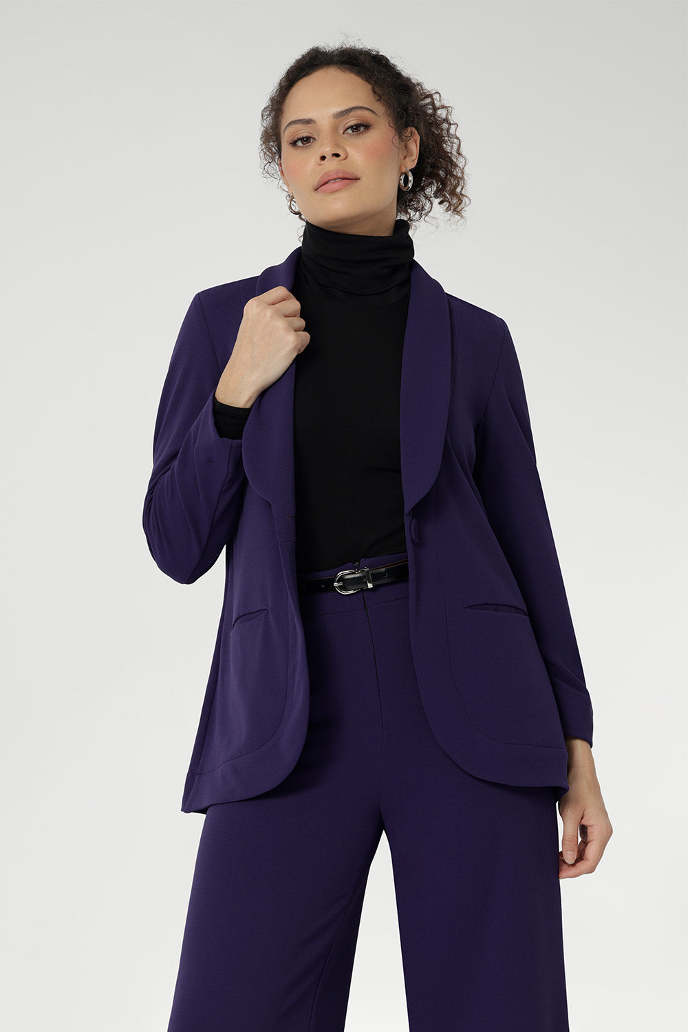 The body-contouring silhouette is enhanced by bust and back darts, while functional slit pockets and a centre-back vent ensure both polish and practicality. Deep hems with refined topstitch detailing and a breathable buggy lining through the back complete this elevated look.